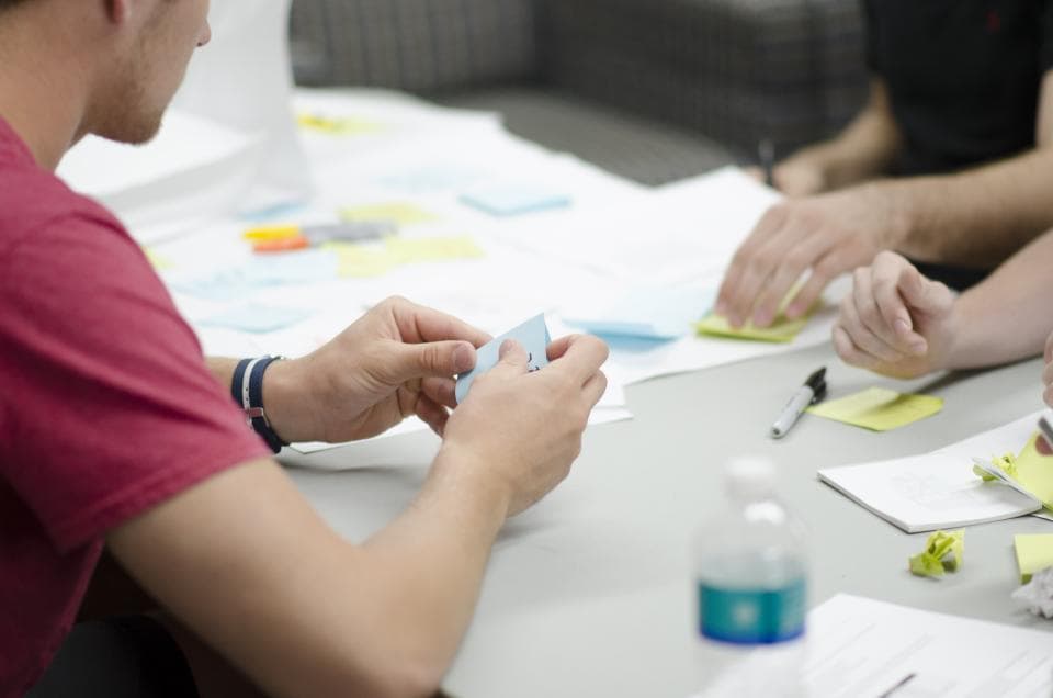 A team sorting sticky notes on a table